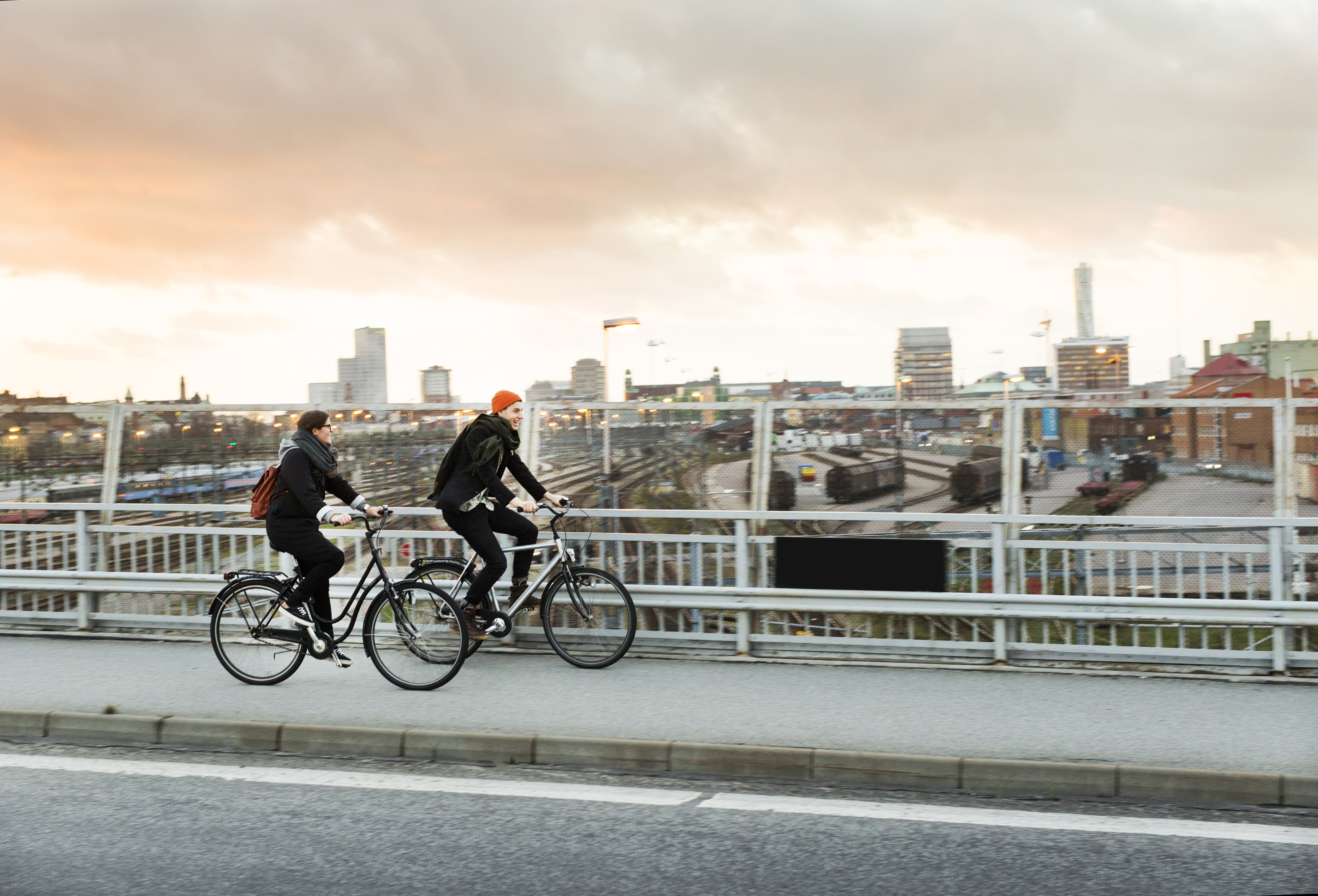 side-view-of-man-and-woman-riding-bicycles-on-bride